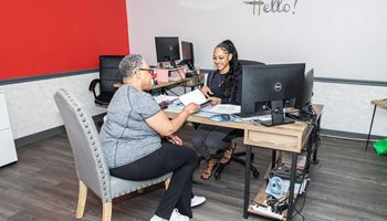Two women sitting at a desk 